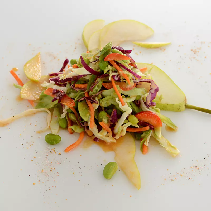 Mound of vegetable slaw on white surface