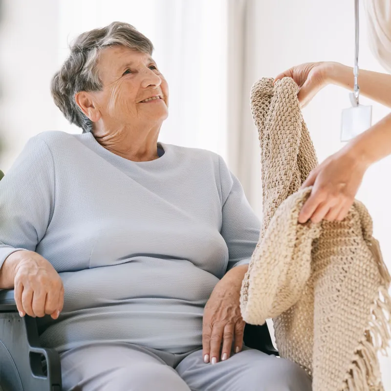 Ederly woman taking blanket from nurse