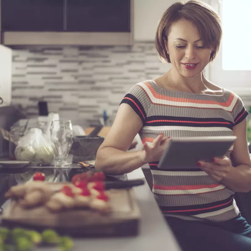 woman in kitchen reading tablet