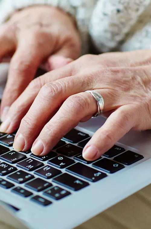 Hands typing on a laptop