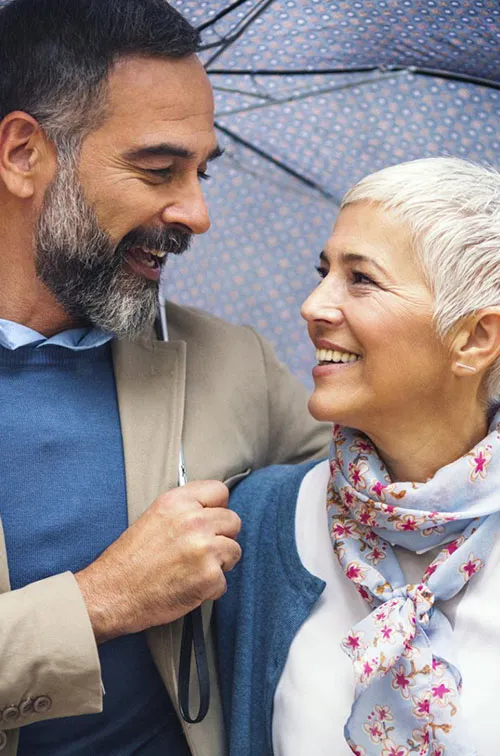 A couple takes a walk under an umbrella.