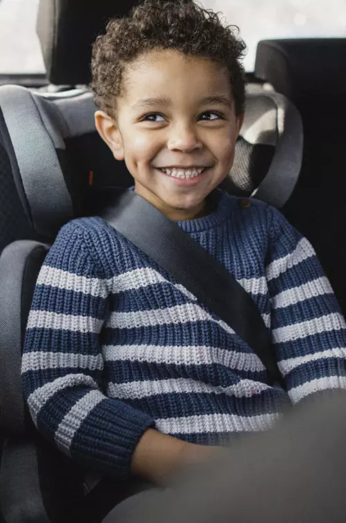 A little boy in a carseat.