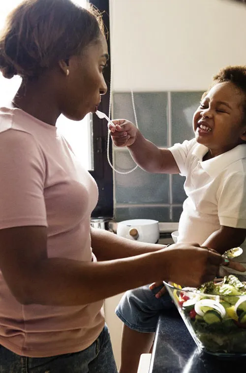 A mom prepares a meal for her family with the help of her toddler. 