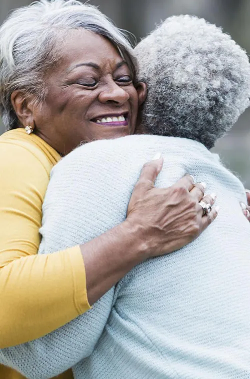 Two lifelong friends hugging.