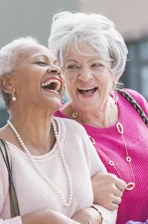 Three women laughing and shopping.