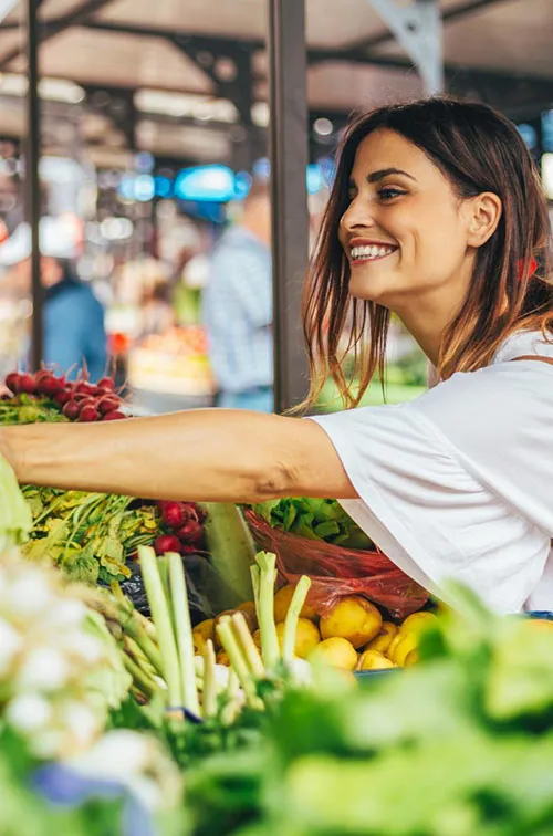 Young woman explores the farmers market for the best produce