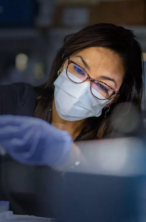 Masked Woman in Lab holding a syringe