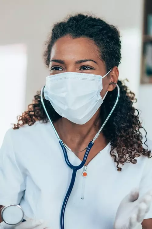 Doctors talking with each other while wearing masks.