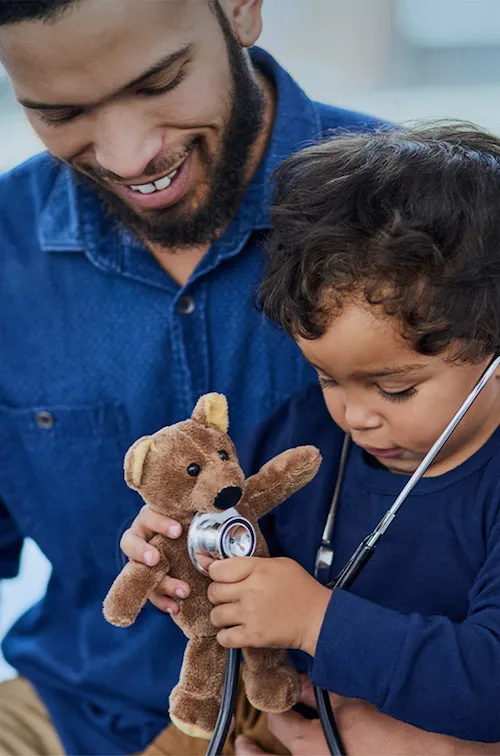 Father and son playing with teddy bear