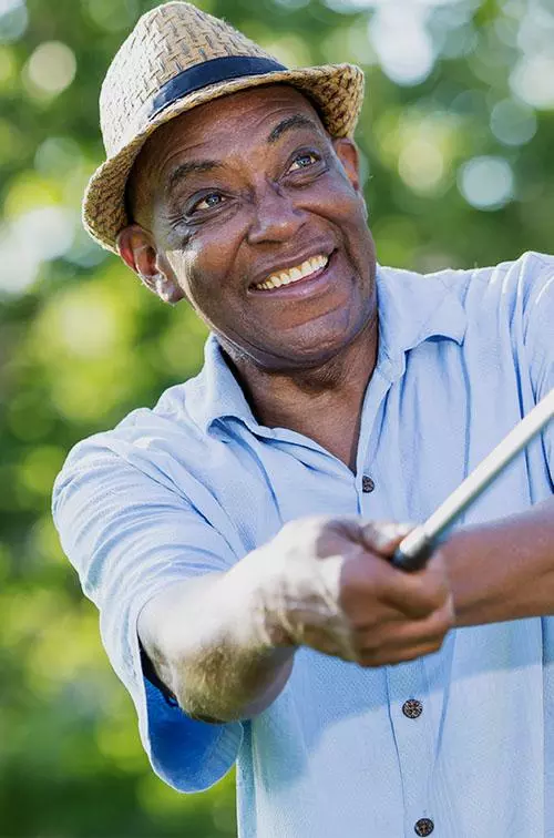 Mature golfer teeing off