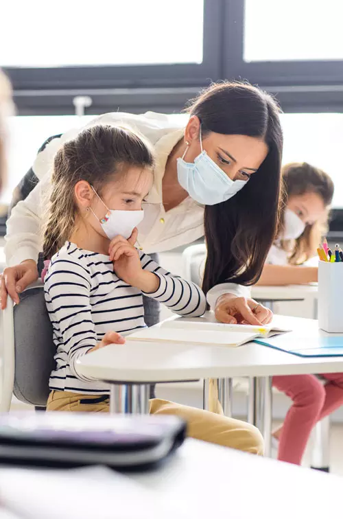 Teacher in classroom with students wearing masks