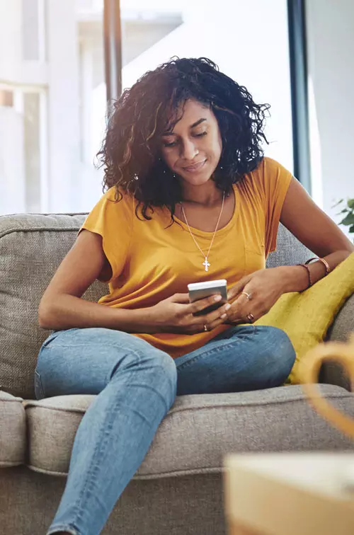 Woman reading phone on couch