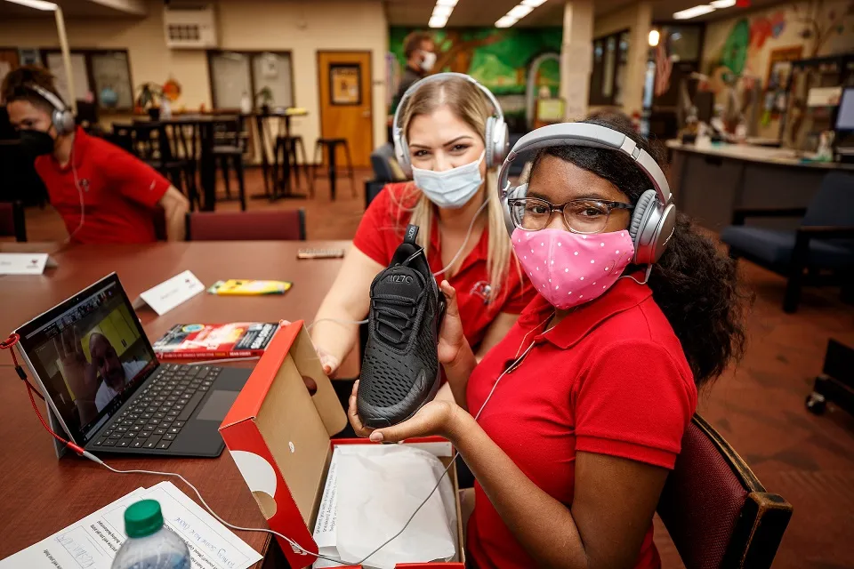 Student smiles after receiving new shoes from AdventHealth