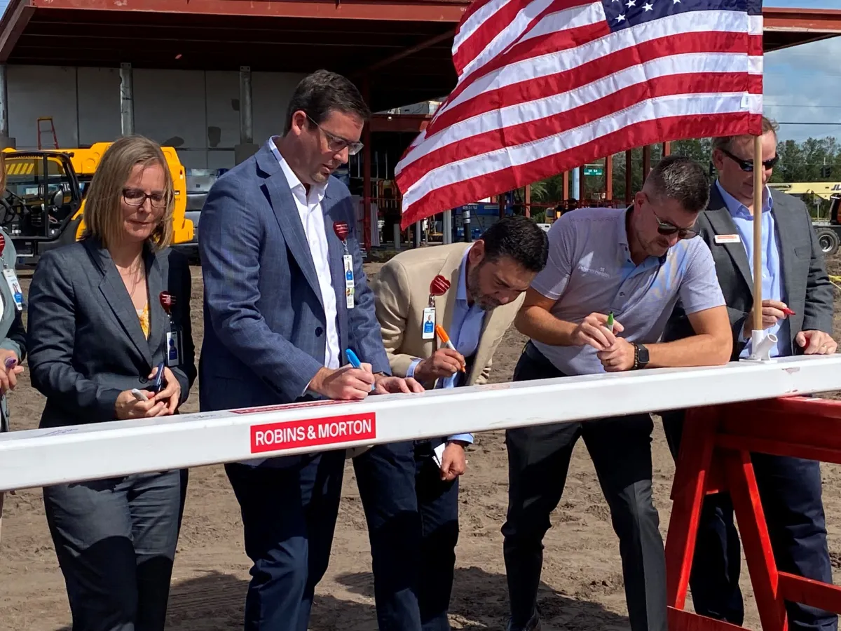 AdventHealth and Robins & Morton leaders sign the beam for AdventHealth Meadow Pointe ER.