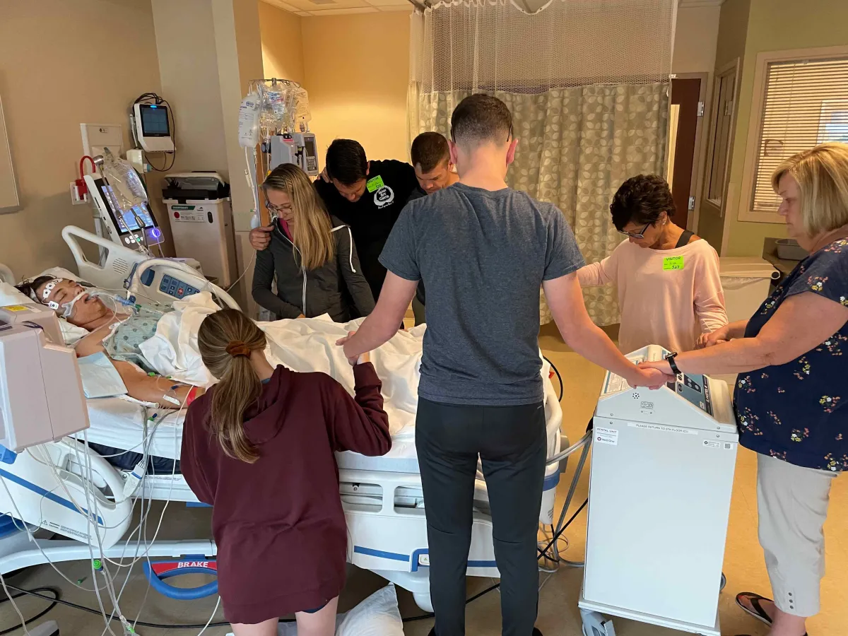 Josiah Stubbs in the ICU at AdventHealth Daytona Beach surrounded by family.