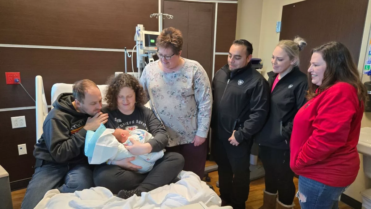 People gathered around a newborn baby