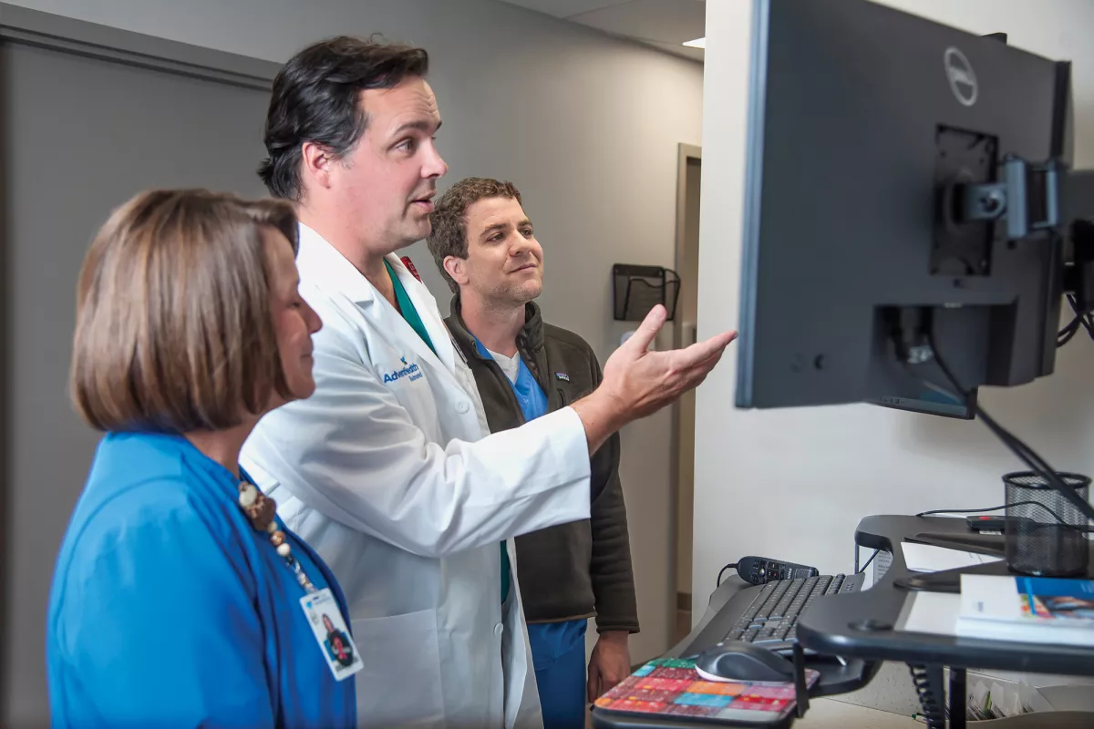 Neurosurgeon John Cowan, MD, speaking with team members