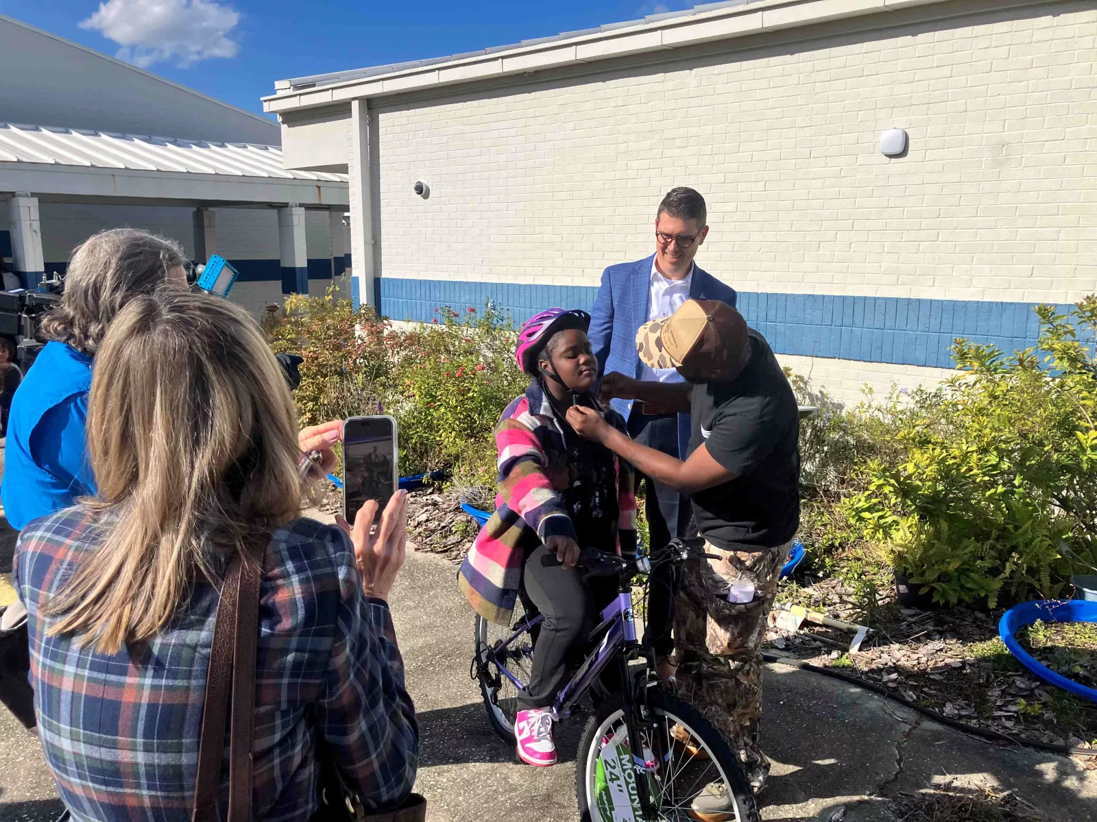 Student is fitted with helmet to go along with her new bike provided by AdventHealth.