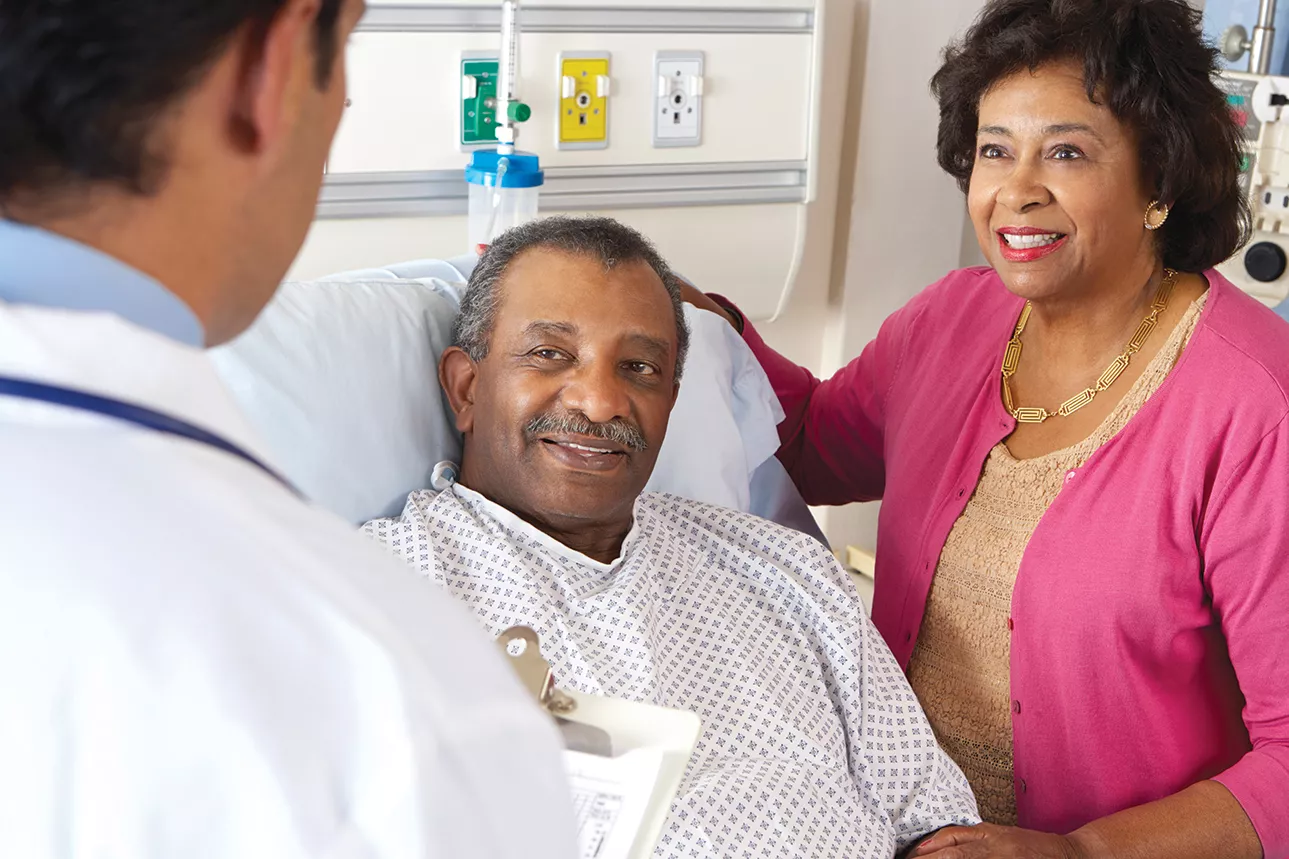 Doctor visiting patient in bed.