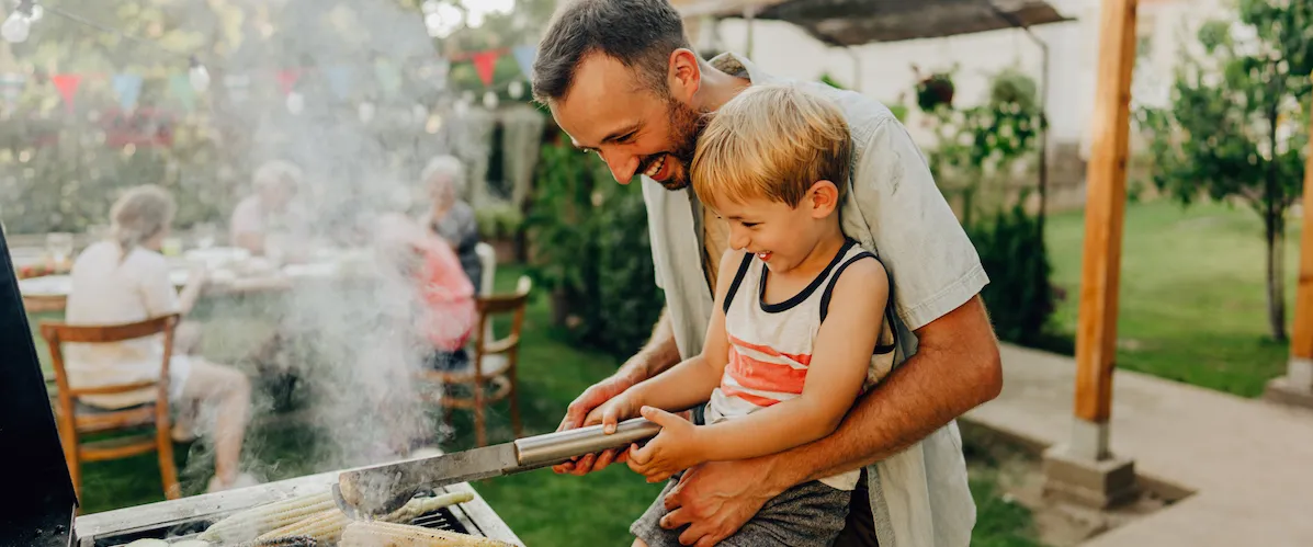 father son grill corn on the barbeque grill summer time