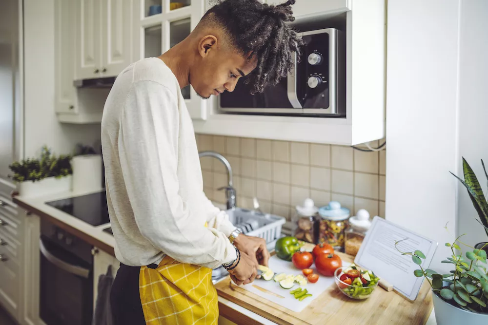 man chops vegetables to maintain a healthy lifestyle