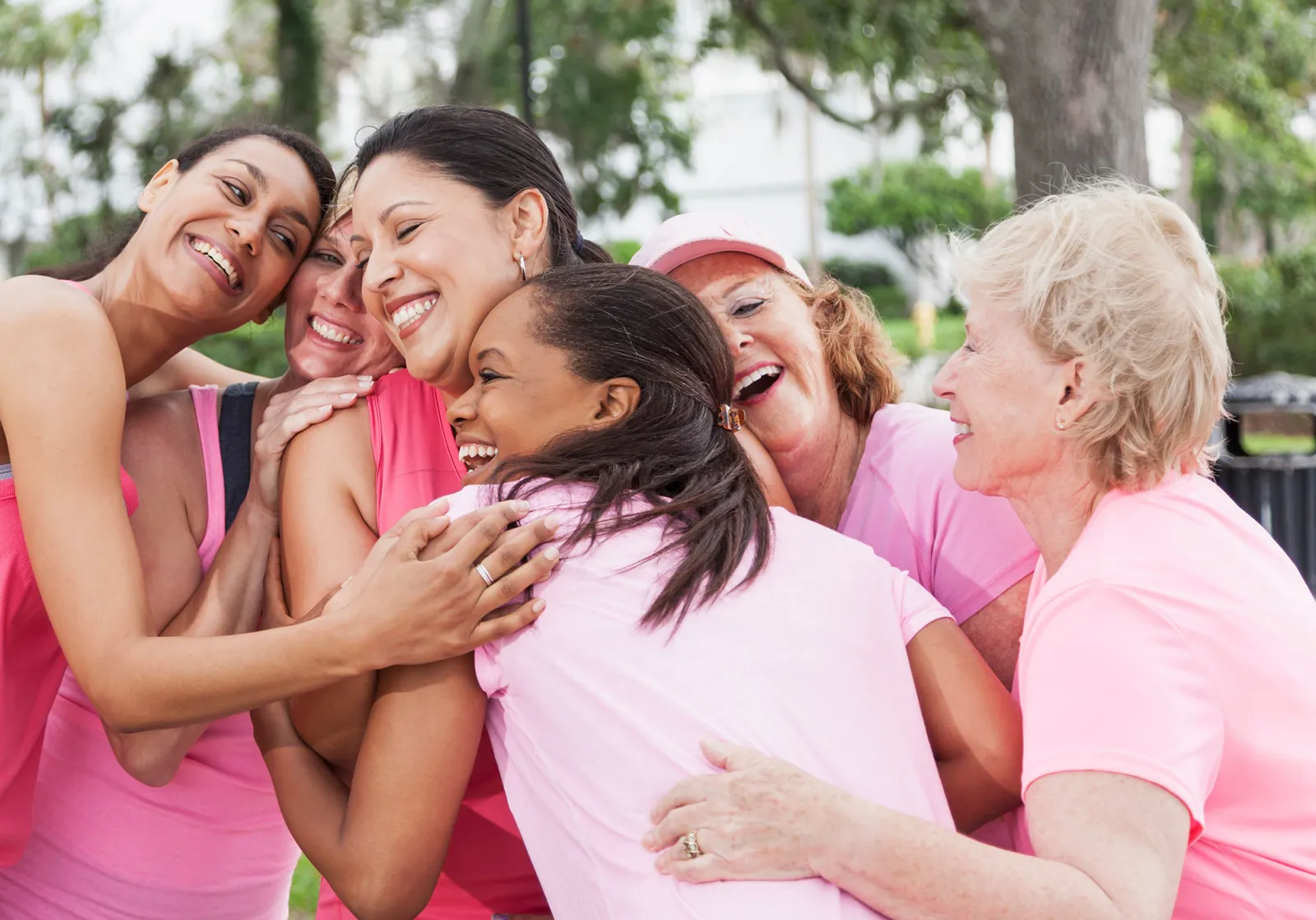 women wearing pink shirts and hugging