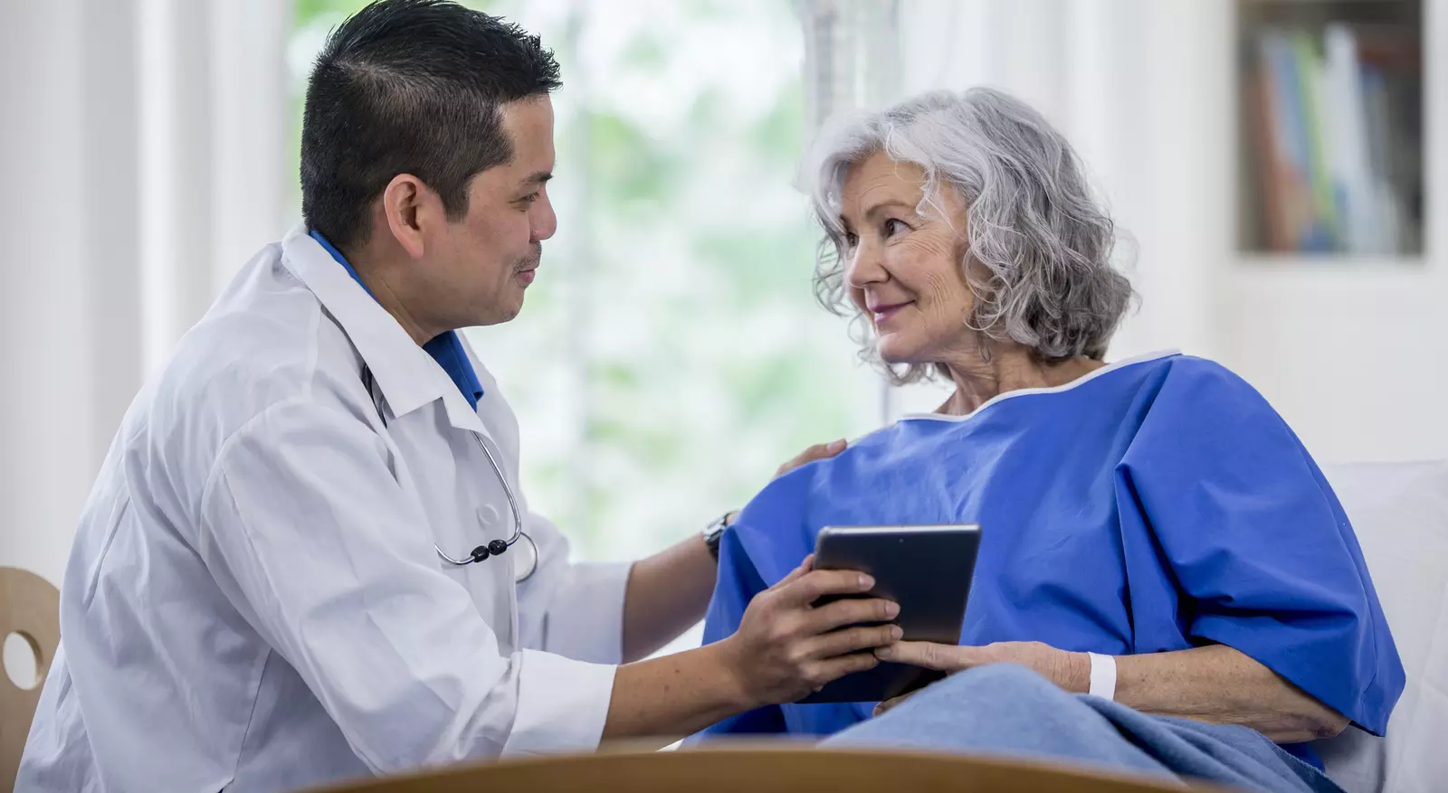 A male doctor and a senior woman patient, consulting.