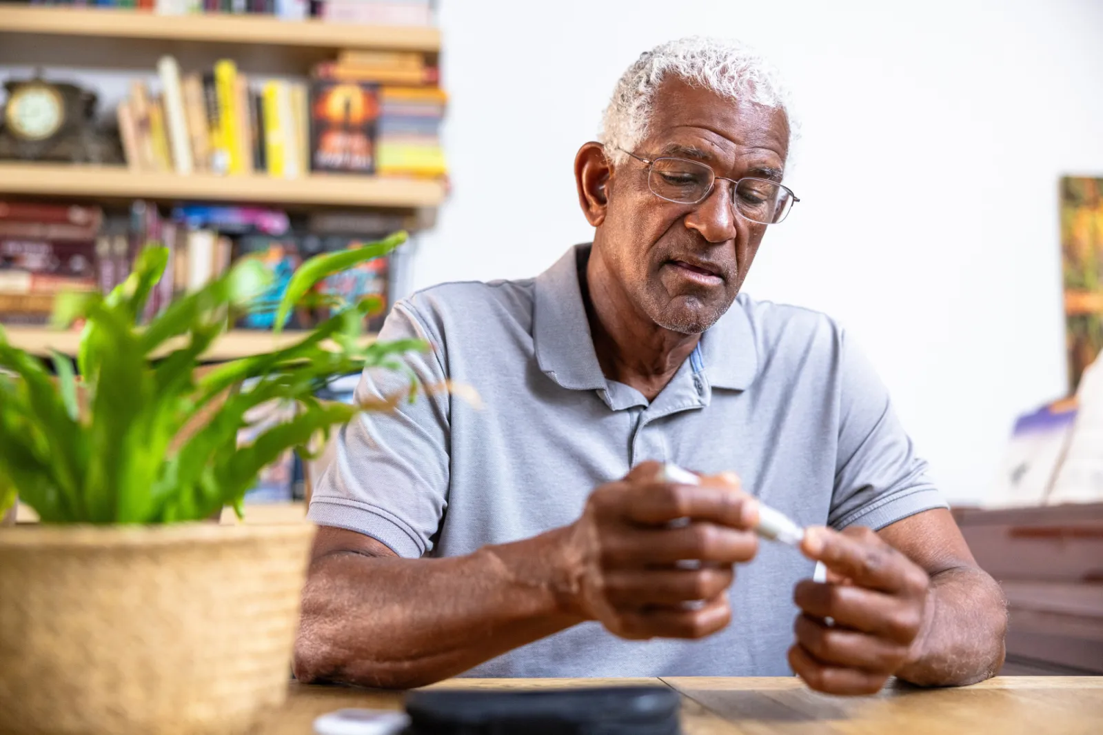 An older man using a blood sugar measuring device