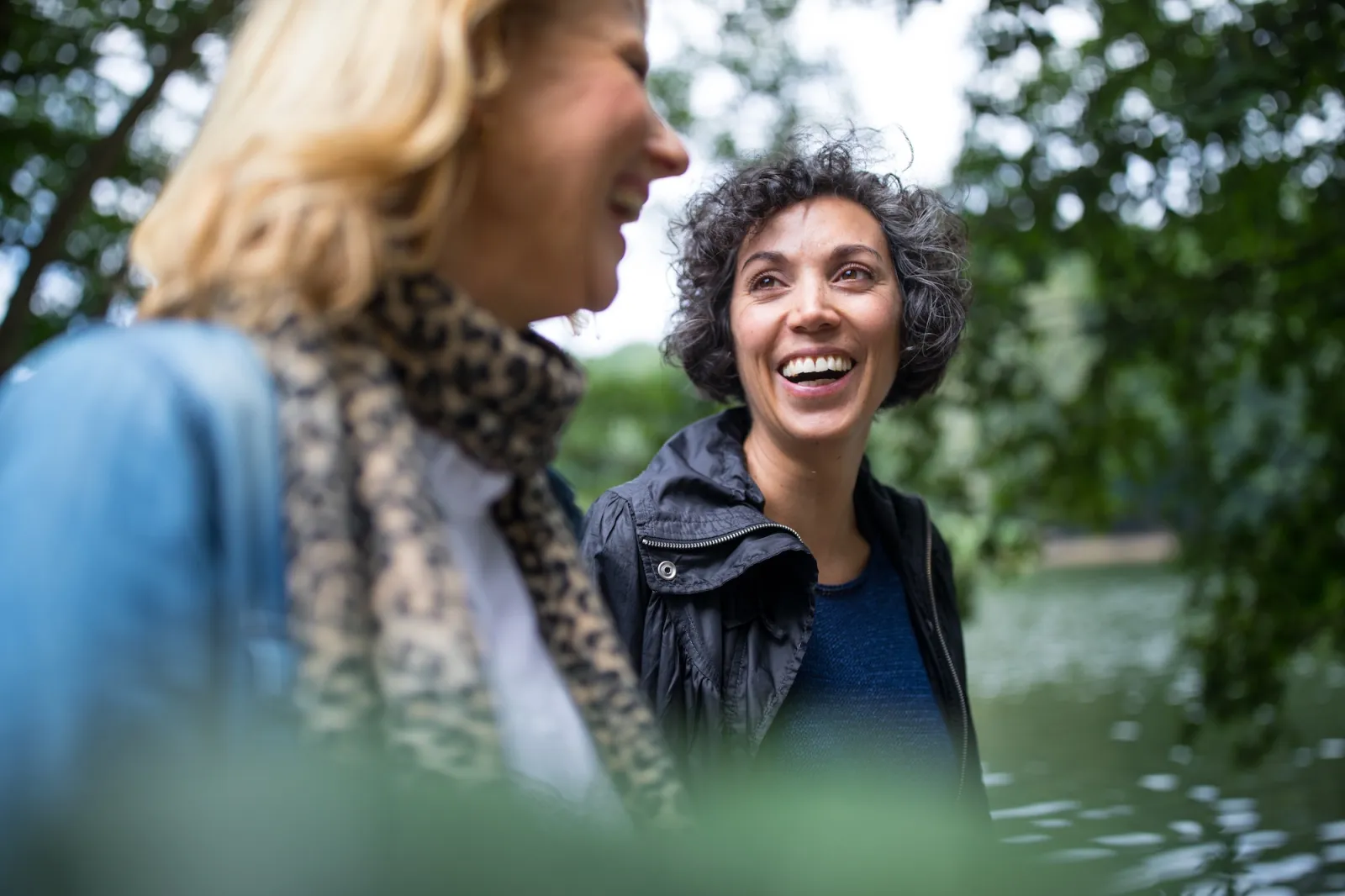 Two smiling women walking outdoors.