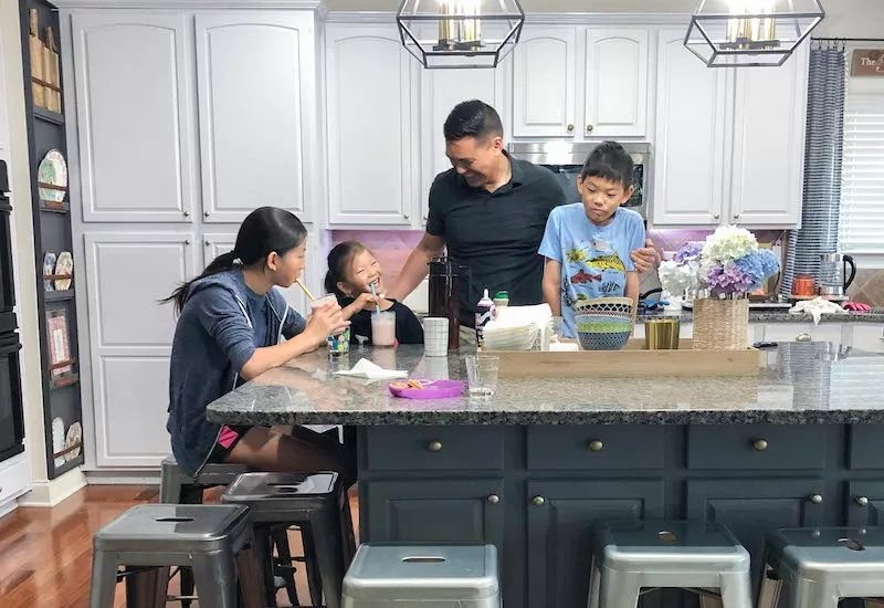 Family laughing in kitchen