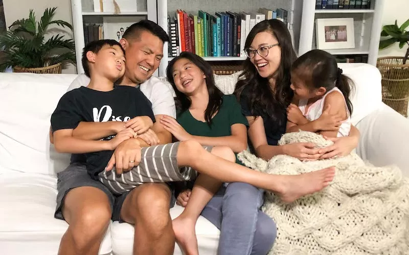 Family laughing on couch