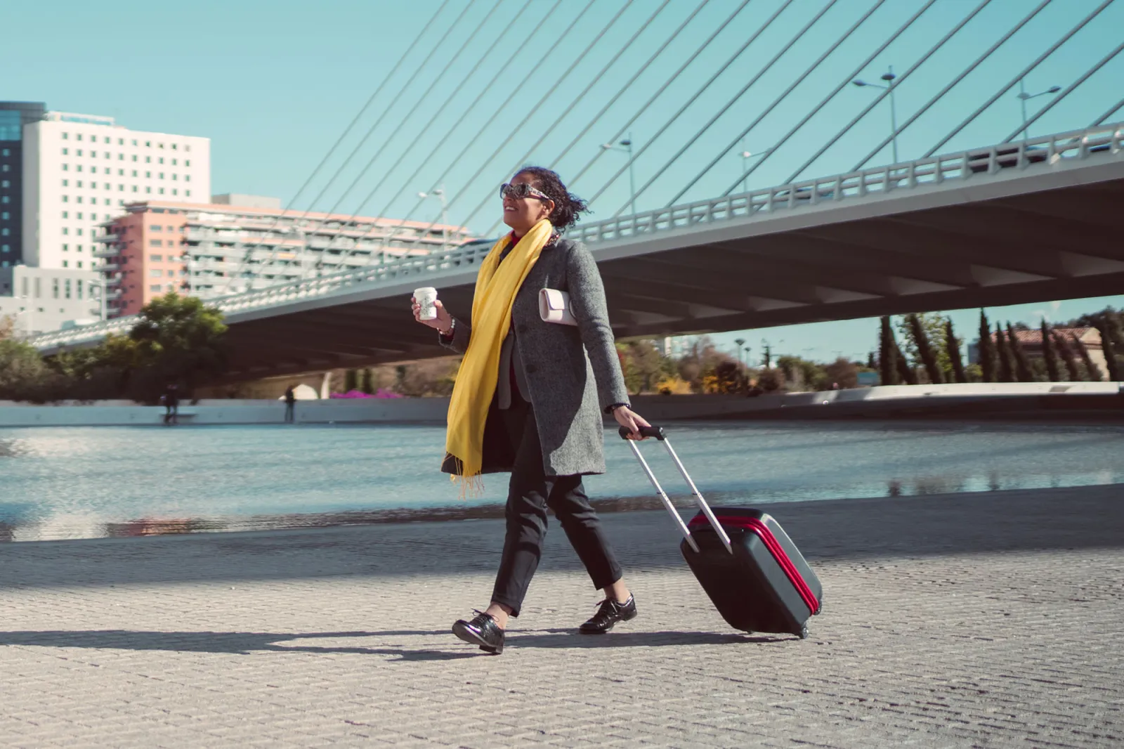 A young woman rolls her suitcase as she travels