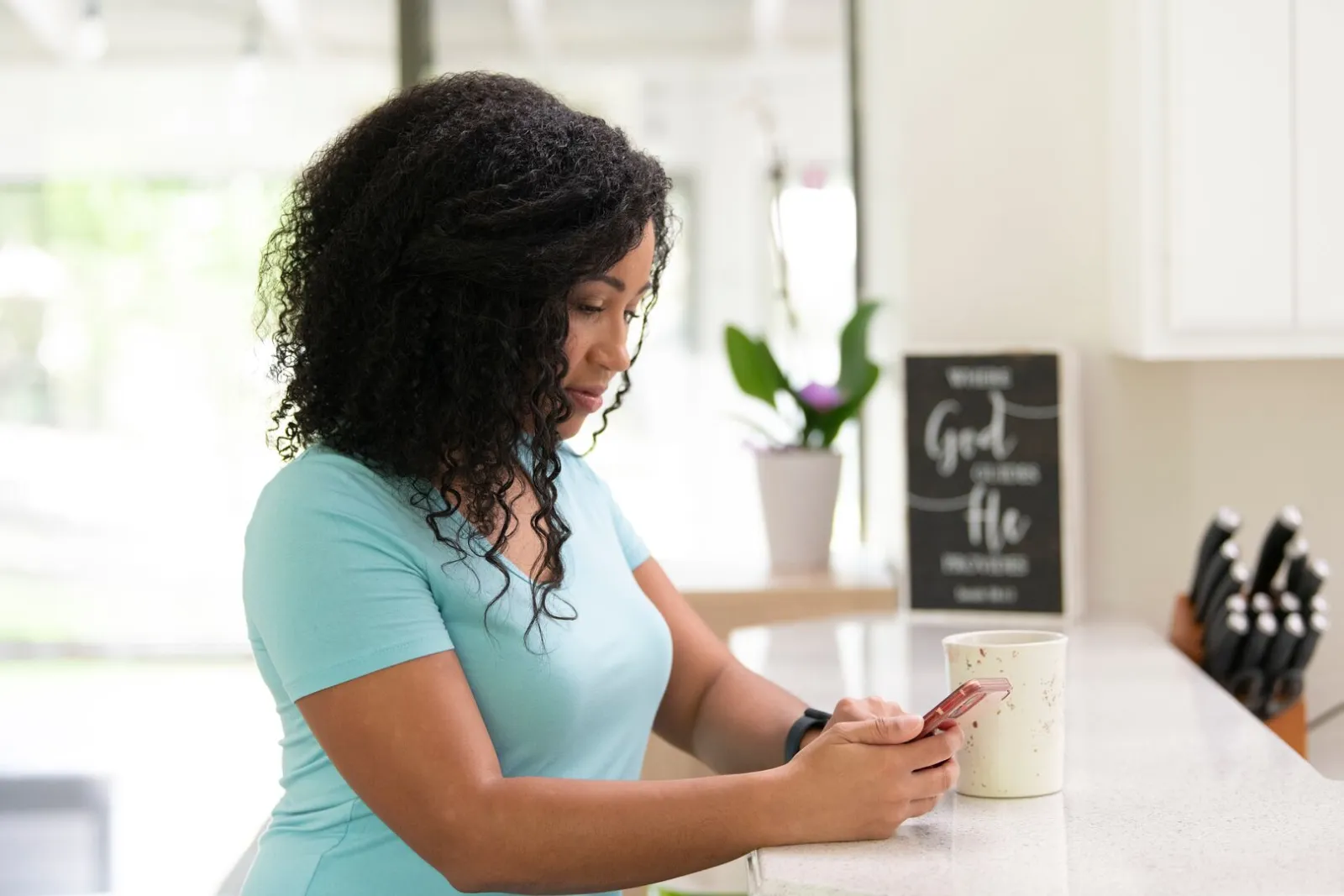 Woman at home on phone side profile serious