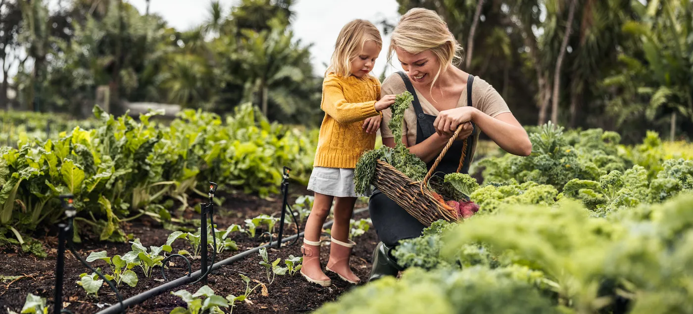 woman gardens with her young daughter