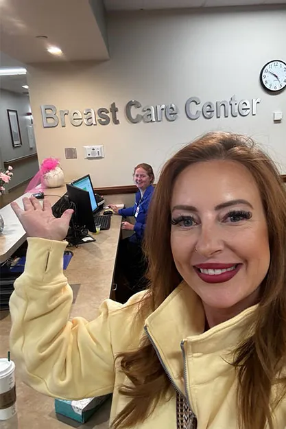 Patient standing in front of a sign that says Breast Care Center