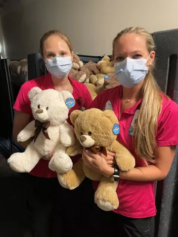 two women holding teddy bears