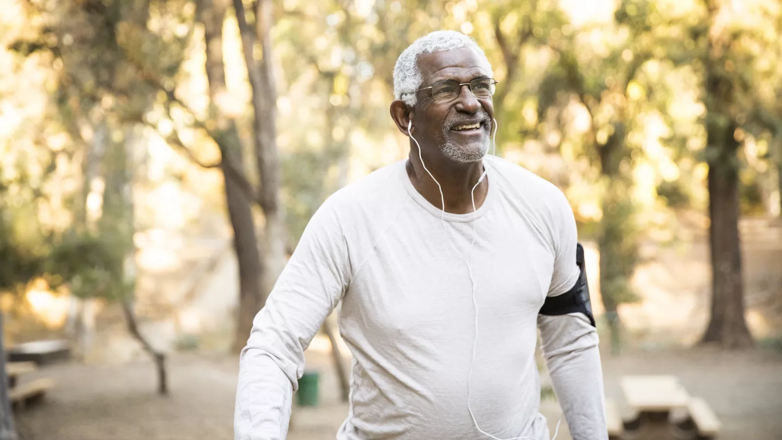 Older African American man walking outdoors.